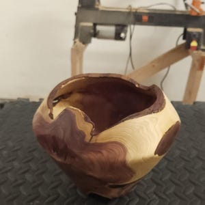 Peut inclure: Bol en bois tourné à la main, de forme naturelle et organique. Le bol présente une combinaison de tons de bois brun clair et brun rougeâtre foncé. L'intérieur est brun foncé. Une pièce décorative unique pour la maison.