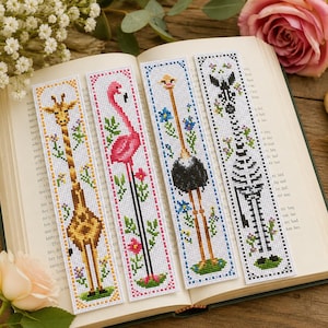 May include: Four rectangular cross-stitch bookmarks featuring animal designs. The first shows a giraffe, the second a pink flamingo, the third an ostrich, and the fourth a black and white zebra skeleton, all surrounded by small floral accents.
