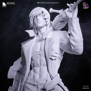 May include: A white, unpainted resin figurine of a character with layered hair, wearing an open jacket over a bare chest, and holding a large sword with a skull-shaped hilt over the shoulder. The figure features detailed abdominal muscles.