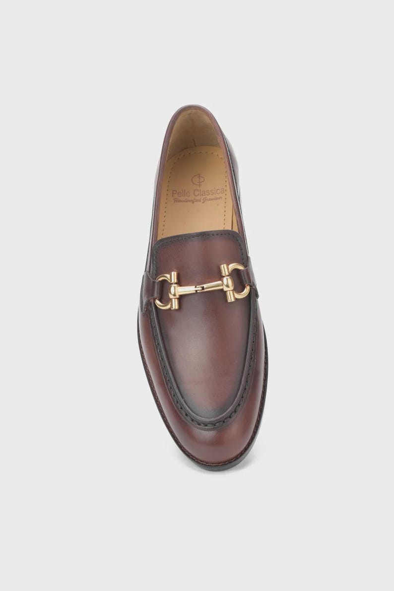 Handmade mahogany brown leather horsebit loafers for men featuring a gold metal horsebit, moc toe stitching, premium leather construction, and classic slip-on design for formal and business casual wear.