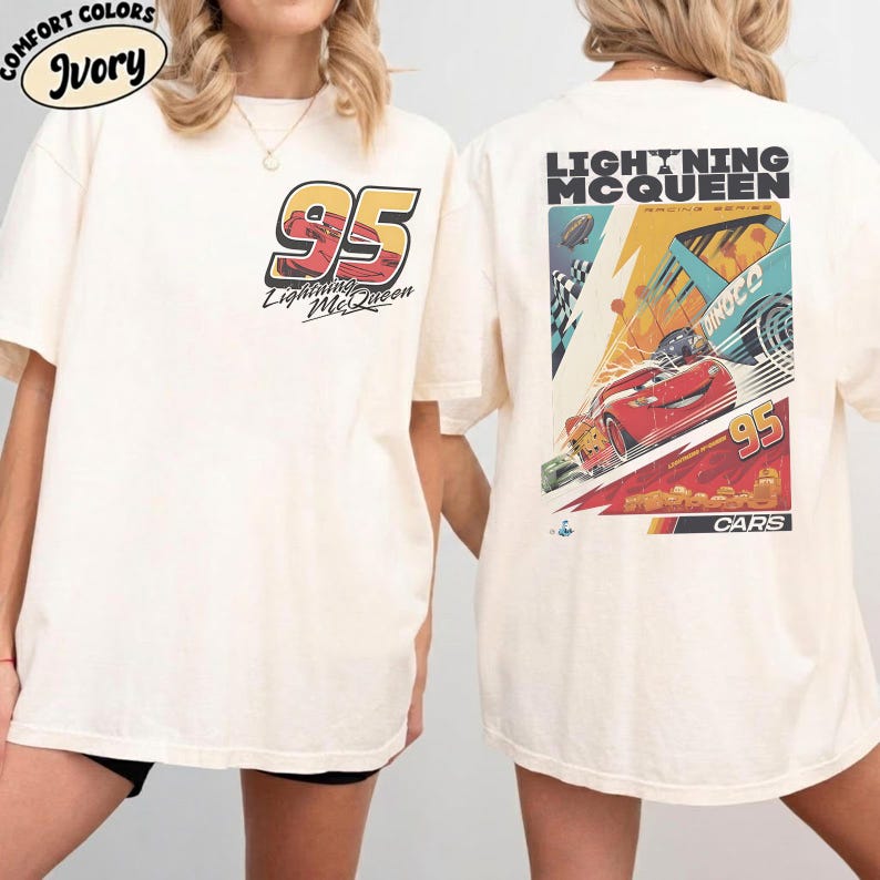 May include: Ivory-colored t-shirt featuring the number 95 and the words "Lightning McQueen" in a racing-themed design on the front. The back of the shirt displays a colorful graphic with Lightning McQueen and the text "Lightning McQueen Racing Series".