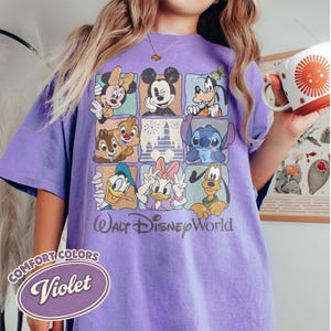 May include: A violet Comfort Colors t-shirt featuring a grid of Disney characters including Mickey Mouse, Minnie Mouse, Donald Duck, and Stitch. The shirt has the words "Walt Disney World" printed below the grid. A violet oval with the word "Violet" is in the lower left.
