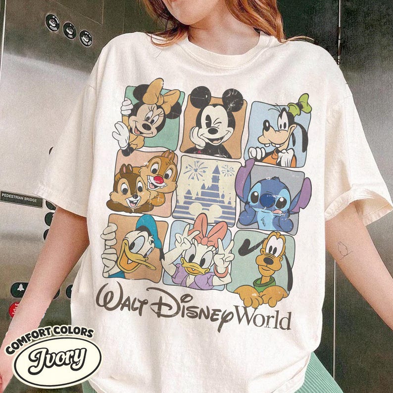 May include: Ivory-colored t-shirt featuring a grid of Disney characters including Mickey Mouse, Minnie Mouse, Goofy, Donald Duck, Daisy Duck, Chip and Dale, Stitch, and Pluto. The words "Walt Disney World" are printed below the grid.