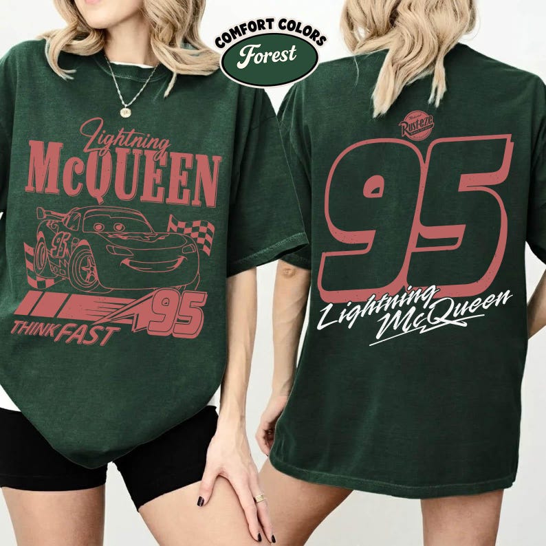 May include: Forest green t-shirt featuring Lightning McQueen graphics. The front displays the car, the text "Lightning McQueen", "95", and "Think Fast". The back has a large "95" and "Lightning McQueen" text.