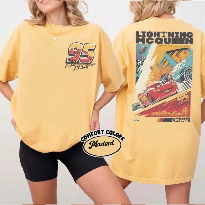 May include: Mustard-colored t-shirt featuring Lightning McQueen graphics. The front displays the number 95 and the character's name. The back showcases a racing scene with Lightning McQueen, the number 95, and the text "Cars".