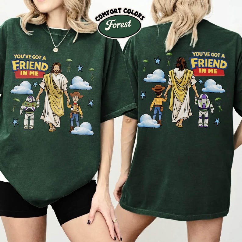 May include: Forest green t-shirt with the text "YOU'VE GOT A FRIEND IN ME" and a graphic of Jesus, Woody, and Buzz Lightyear. The shirt also features clouds, stars, and parachutes.