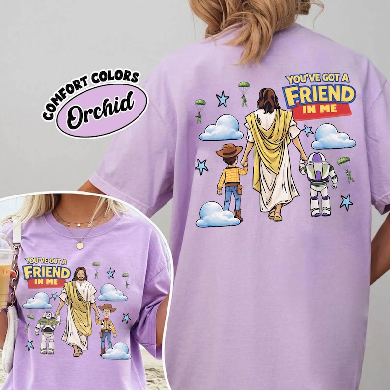 May include: Lilac Comfort Colors t-shirt with a graphic of Jesus, a child, and Buzz Lightyear, with the text "YOU'VE GOT A FRIEND IN ME." The design includes clouds, stars, and parachutes.