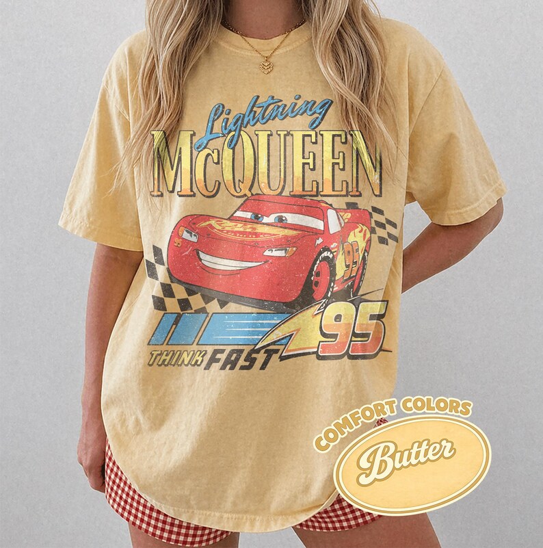 K&ouml;nnte beinhalten: Gelbes T-Shirt mit Lightning McQueen aus dem Film Cars. Die Grafik enth&auml;lt den Text "Lightning McQueen", "95" und "Think Fast". Das Shirt ist mit "Comfort Colors Butter" gekennzeichnet.