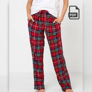 May include: Red plaid pajama pants with a drawstring waist and pockets. The pants feature a pattern of red, green, and blue lines. The person in the image is wearing a white t-shirt.