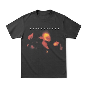 May include: Black t-shirt featuring the band name "SOUNDGARDEN" in white block letters above a blurred, fiery image. The graphic has shades of red, orange, and yellow. The shirt is a classic crew neck style.