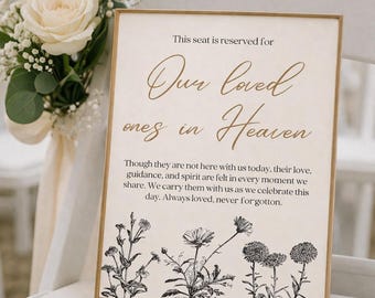 May include: A rectangular sign in a thin gold frame featuring the text: This seat is reserved for Our loved ones in Heaven. Though they are not here with us today, their love, guidance, and spirit are felt in every moment we share. Always loved, never forgotten. The bottom features black botanical illustrations of wildflowers.