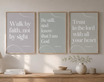 May include: Three framed wall art prints featuring white text on muted backgrounds. The left print reads Walk by faith, not by sight. The centre print reads Be still, and know that I am God. The right print reads Trust in the lord with all your heart.