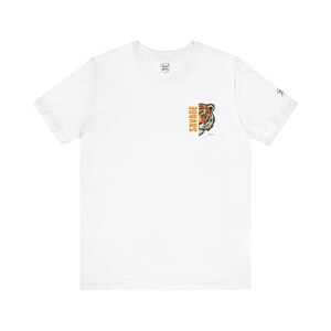 May include: White t-shirt with a tiger graphic and the word "SAVAGE" printed vertically in orange. The tiger graphic is orange, brown, and black. The shirt has a crew neck and short sleeves.