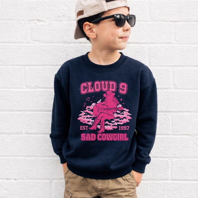 May include: A white ceramic mug with a black handle and the text "But First, Coffee" in a black, handwritten-style font. The mug likely holds between 325-440 ml.