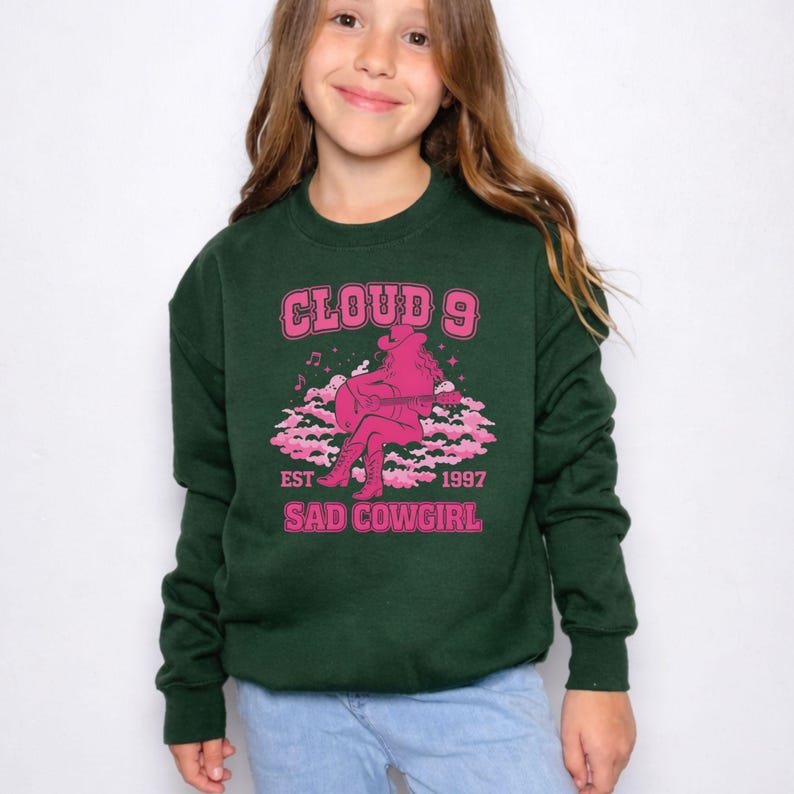 May include: A white ceramic mug with a black handle and the text "But First, Coffee" in a bold, black font. The mug is set against a blurred background, suggesting a cosy setting.