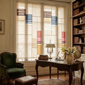 Puede incluir: Cortinas de ventana transparentes con un patrón de cuadrícula de paneles de tela beige acentuados con bloques rectangulares de color marrón, azul, rojo y amarillo. Las cortinas cuelgan frente a una ventana grande, permitiendo que la luz se filtre.