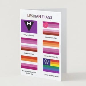 May include: A folded card showing different lesbian flags. The card includes flags with pink, orange, and purple stripes, and a purple flag with a black labrys symbol. The text on the card reads "LESBIAN FLAGS".