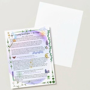 May include: A printed card titled "Creating Sacred Space - In 7 Steps" with decorative elements. The card features text, illustrations of moons, feathers, and plants, and a purple and green border. A blank white card is behind it.