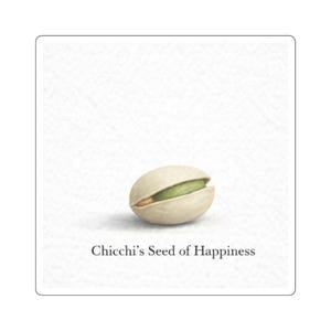 Puede incluir: Una sola pistacha, parcialmente abierta, que revela un núcleo verde vibrante. La nuez se encuentra sobre un fondo blanco texturizado. El texto "Chicchi's Seed of Happiness" está impreso debajo.