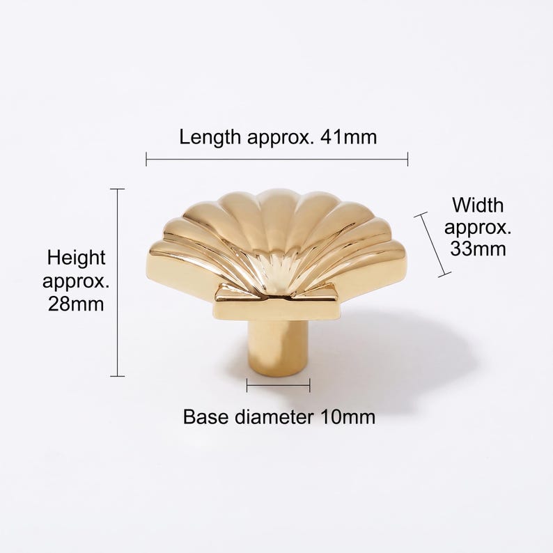 May include: A gold-colored cabinet knob shaped like a seashell. The knob features a ribbed fan design and a cylindrical base. Dimensions are labeled as length approx. 41mm, width approx. 33mm, height approx. 28mm, and a base diameter of 10mm.