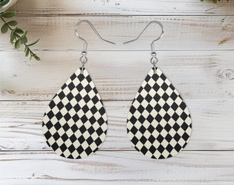 May include: A pair of teardrop-shaped dangle earrings featuring a black and white checkered diamond pattern. The earrings are suspended from silver-toned metal fishhook ear wires, creating a classic geometric design for everyday wear.