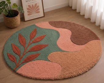 Tappeto rotondo in lana trapuntato a mano, con motivo astratto di foglie botaniche, ideale per un arredamento moderno e naturale del soggiorno.
