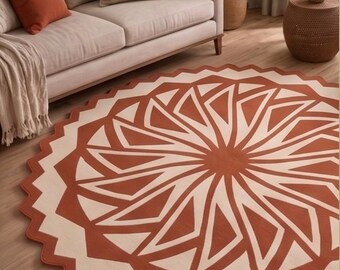 Tappeto rotondo in lana trapuntato a mano, con motivo geometrico a raggiera e bordo smerlato, color terracotta avorio (prodotto in India).