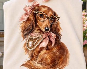PNG de Dachshund em aquarela, cachorrinho salsicha de pelo comprido fofo com laço e óculos de oncinha, design de sublimação para cachorro charmoso. Download digital.