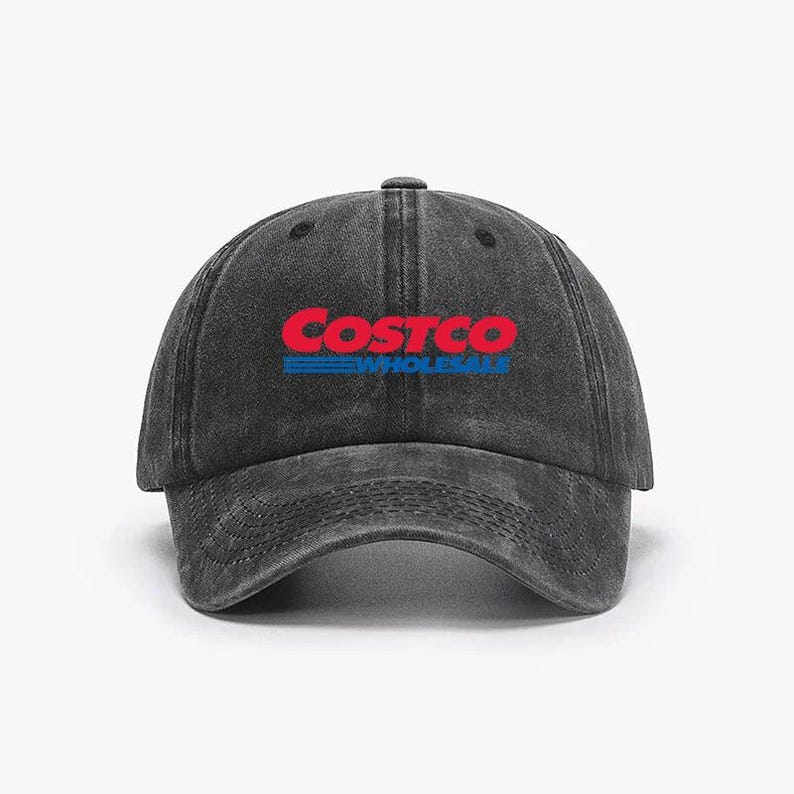 May include: A black, distressed-look baseball cap with the Costco Wholesale logo in red and blue. The cap has a curved brim and an adjustable strap at the back. The logo is embroidered on the front.