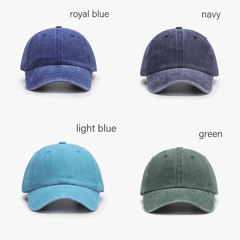 May include: Four baseball caps in royal blue, navy, light blue, and green. Each cap has a curved brim and a fabric strap closure. The caps are displayed against a white background, with the color names above each cap.