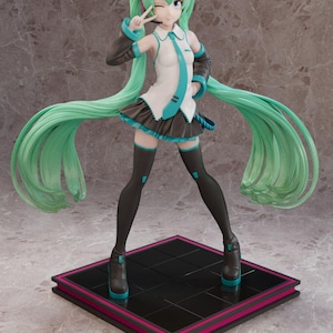 May include: A figurine of a female anime character with long, flowing turquoise hair and a matching tie. She wears a white top, a black skirt, and black thigh-highs. The figure is posed on a black and pink platform, with a headset.