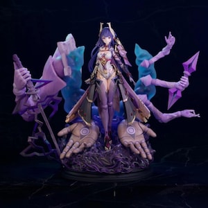 May include: A detailed figurine of a female character with purple and gold armor, standing on a base with stylized hands and swirling purple energy. The figure has long purple hair and is surrounded by translucent purple and blue energy effects.