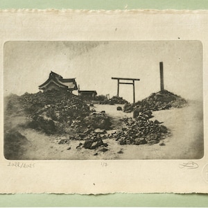 May include: Monochrome print of a Japanese landscape featuring a traditional building, a torii gate, and a tall wooden post atop a rocky terrain. The print is on textured paper with deckled edges. The print is numbered 2022/2025 and 1/7.