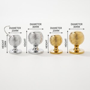Pode incluir: Quatro puxadores esf&eacute;ricos para arm&aacute;rios com texturas estriadas horizontais. Dois s&atilde;o prateados com 25 mm de di&acirc;metro e 33 mm de altura, e 30 mm de di&acirc;metro e 42 mm de altura. Dois s&atilde;o dourados com as respetivas medidas de altura indicadas.