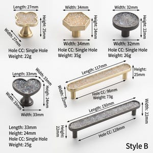 May include: A collection of six cabinet knobs and pulls in gold and dark metal finishes with textured crystal-like inlays. Each item includes printed dimensions in millimeters, weight in grams, and hole spacing specifications labeled as Style B.