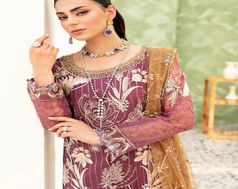 May include: A plum-colored formal dress with intricate gold embroidery and sheer sleeves. The dress features a detailed floral pattern and is accessorized with matching jewelry and a gold-toned scarf.