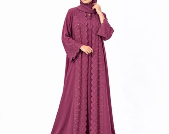 May include: A floor-length, deep mauve abaya featuring a matching hijab. The garment includes a central vertical panel of intricate, scalloped-edge lace detailing that extends from the neckline to the hem, with matching lace trim on the sleeves.
