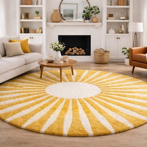 Puede incluir: Una alfombra redonda con diseño de rayos de sol. La alfombra presenta un centro blanco con rayas amarillas y blancas que irradian. Se coloca sobre un suelo de madera en un salón, con un sofá, un sillón y una chimenea visibles.
