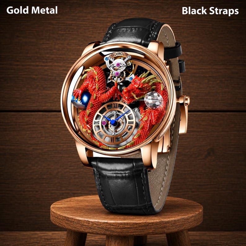 Op de afbeelding: Gouden metalen horloge met zwarte bandjes. Het horloge heeft een gedetailleerd rood drakenontwerp in de wijzerplaat, met zichtbare tandwielen en een blauw geaccentueerde wijzerplaat. Het horloge wordt gepresenteerd op een kleine houten standaard.
