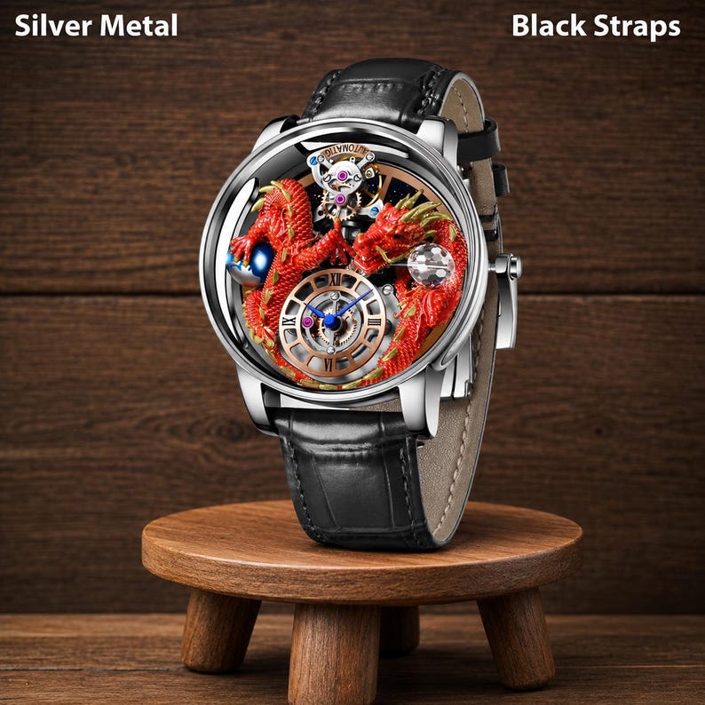 Op de afbeelding: Een zilveren polshorloge met zwarte bandjes. De wijzerplaat van het horloge heeft een gedetailleerd rood drakenontwerp met een blauwe en gouden wijzerplaat. Het horloge wordt gepresenteerd op een kleine houten kruk.