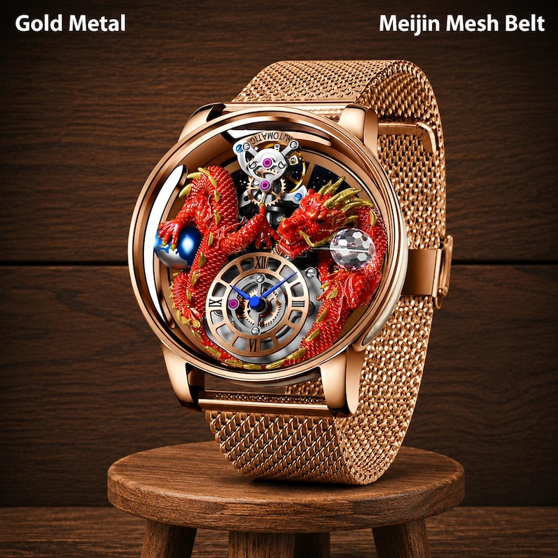 Op de afbeelding: Goudkleurig horloge met een mesh band. De wijzerplaat van het horloge heeft een rood drakenontwerp met ingewikkelde mechanische details. Het horloge wordt getoond op een kleine houten kruk. De tekst "Gold Metal" en "Meijin Mesh Belt" zijn zichtbaar.