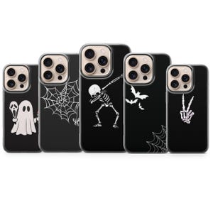 Puede incluir: Cinco fundas negras para smartphone dispuestas en fila, cada una con un diseño gráfico blanco. Los diseños incluyen un fantasma con un cuchillo, una telaraña con una araña, un esqueleto haciendo un dab, murciélagos volando y una mano esquelética.