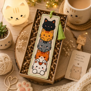 Adorable cat stack cross stitch bookmark pattern featuring five kawaii cats peeking one above another in black, orange, gray, orange-and-white, and white colors. This cute animal bookmark design is stitched with 9 DMC colors and measures 40 × 125 stitches. Perfect for cat lovers, bookworms, and beginner to intermediate cross stitch enthusiasts. Ideal as a handmade reading accessory, thoughtful gift, or DIY embroidery project with instant PDF download for creating a charming bookmark.