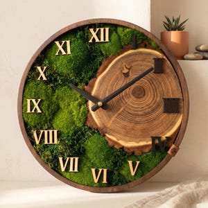 May include: A round wall clock with a dark wood frame, featuring a natural wood slice segment on the right side and vibrant green preserved moss on the left. The clock face displays black Roman numerals and two black hands for timekeeping.