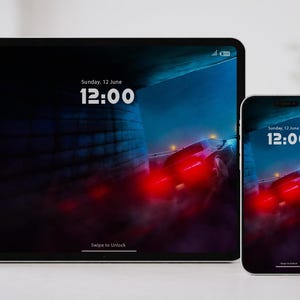 Könnte beinhalten: Ein Tablet und ein Smartphone zeigen einen digitalen Hintergrund mit einer Autorennszene. Die Bildschirme zeigen die Uhrzeit 12:00 Uhr und das Datum Sonntag, 12. Juni. Der Hintergrund ist dunkelblau mit roten Lichtern.