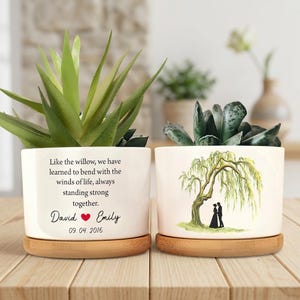 May include: Two white ceramic plant pots with succulents, each on a bamboo saucer. One pot has text: "Like the willow...standing strong together." with names and a date. The other has a willow tree illustration with a couple.