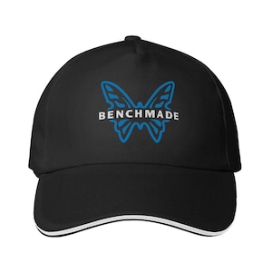 Puede incluir: Gorra de b&eacute;isbol negra con ribete blanco en el borde. La gorra presenta un logotipo de mariposa azul con la palabra "BENCHMADE" en letras blancas. La gorra est&aacute; hecha de una tela duradera.
