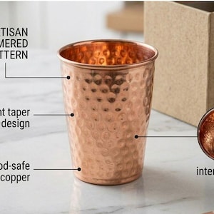 May include: Copper tumbler with an artisan hammered pattern and straight taper design. The food-safe pure copper cup has an interior polish. The image also shows a cardboard box.