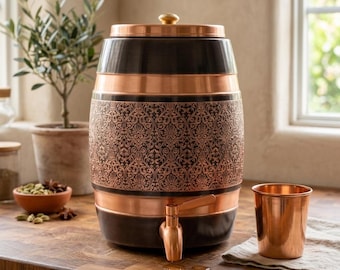 May include: A cylindrical beverage dispenser featuring a dark brown finish with polished copper bands and a central band displaying an intricate embossed floral pattern. It includes a copper lid with a knob and a copper spigot, paired with a copper cup.