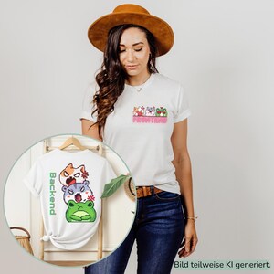 Könnte beinhalten: Ein weißes T-Shirt mit einer kleinen Pixel-Art-Grafik auf der Brust, die drei Tiere und den Text FRONTEND in Pink zeigt. Eine zweite Ansicht zeigt dasselbe weiße T-Shirt mit einem größeren Pixel-Art-Stapel aus drei Tieren und dem Text Backend in Grün.